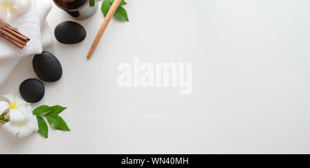 Spa therapy concept : Top view of black stones and towels for massages on white background Stock Photo