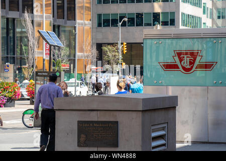 Travellers walk by a TTC sign in-front of Union Station in downtown Toronto. Stock Photo
