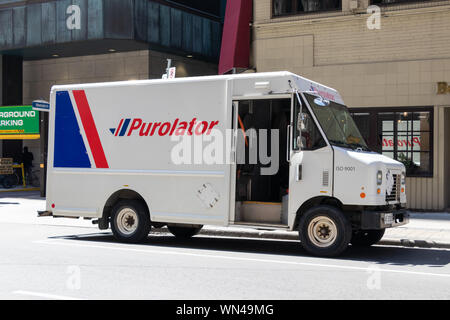 Purolator delivery van stopped on the side of a street in downtown Toronto. Stock Photo