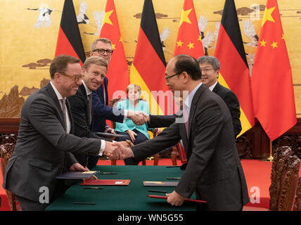 Peking, China. 06th Sep, 2019. Oliver Zipse (2nd from left), Chairman of the Board of Management of BMW, stands before Federal Chancellor Angela Merkel (CDU, M) at the signing of economic agreements, along with other representatives of industry. Merkel also holds a two-day visit to the People's Republic of China Credit: Michael Kappeler/dpa/Alamy Live News Stock Photo