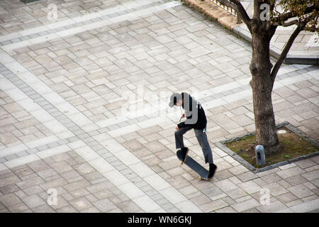 Japanese boy people play and riding skateboard in garden in Ariake town at Koto city on March 25, 2019 in Tokyo, Japan Stock Photo