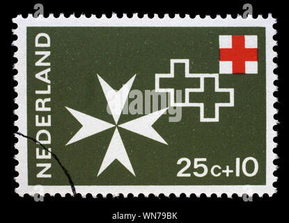 Stamp issued in Netherlands shows Maltese cross, Red Cross serie, circa 1967.. Stock Photo