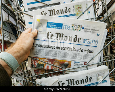 Strasbourg, France - May 18, 2019: POV man hand holding reading latest Le monde Weekend French newspaper featuring European Elections on first page Stock Photo