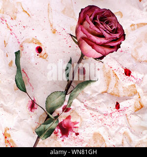 One red rose flower on crumpled aged paper background with paint blots closeup, holiday invitation or greeting card design, vintage floral arrangement Stock Photo