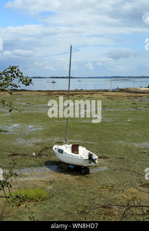 Low tide and moored sailing boat at Anse du Guip from Le Salzen, Ile Aux Moines, Morbihan, Brittany, France Stock Photo