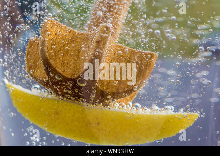 Bubbling water with lemon as a refreshment in summer Stock Photo