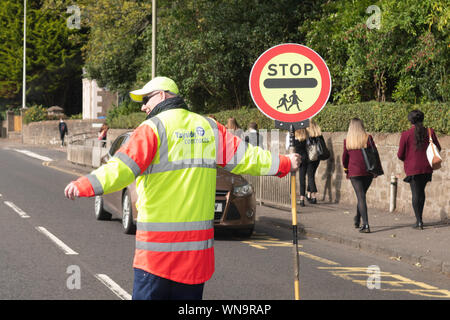 lollipop man person and sign outside school in Scotland, UK Stock Photo