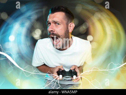 Enthusiastic gamer. Joyful young man holding a video game controller being full of emotions isolated on colorful background. Caucasian player. Getting crazy. Has the worst team in videogame. Stock Photo