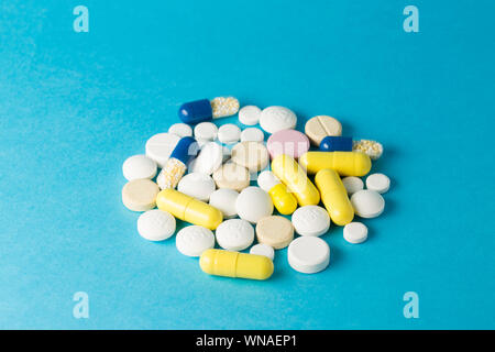 Medicines white,yelow and blue round  shaped pills on blue background Stock Photo