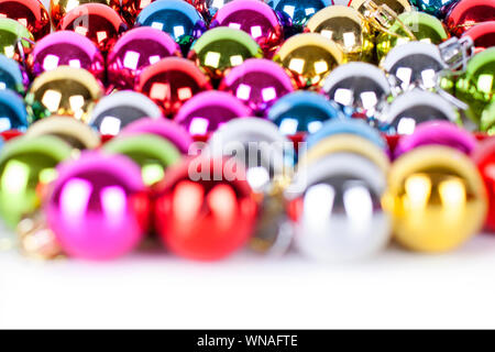 Christmas and New Year pattern, ornament of bright multi-colored glass decorative balls, blurred bokeh, on white background isolated close up Stock Photo