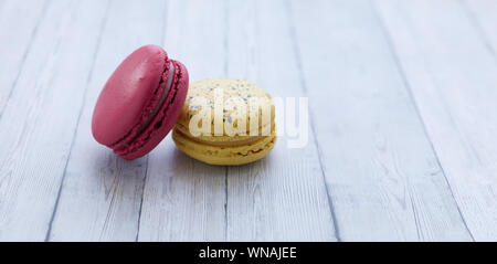 Yellow and red macaroons on wooden table Stock Photo