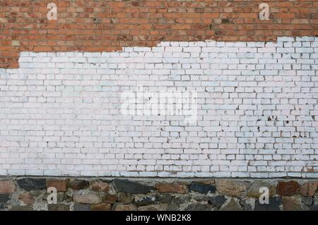 Residental house wall with white paint patches covering graffiti vandalism on exterior Stock Photo