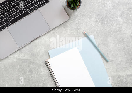 Flat lay, top view office table desk. Workspace with laptop computer, female diary, succulent plant on concrete stone background. Feminine workspace c Stock Photo