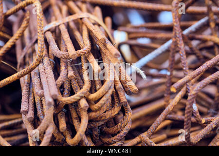 Rusty steel parts on a construction site with a blade of grass in between Stock Photo