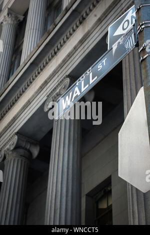 America money, gloomy view of a Wall Street sign against the colonnaded facade of the old National Bank building (now Cipriani), NYC, USA Stock Photo