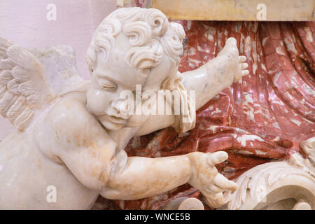 CATANIA, ITALY - APRIL 7, 2018: The angels and baroque marble stoup in Chiesa di San Nicolo. Stock Photo