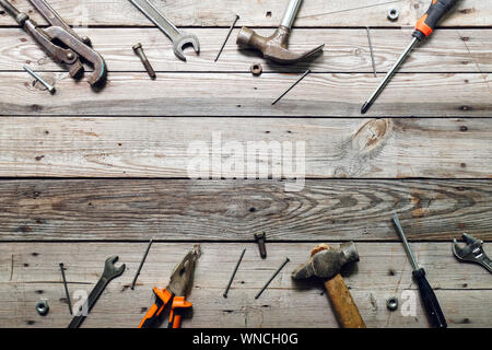 Flat lay composition with vintage carpentry tools on rough wooden background. Top view workbench with carpenter different tools. Woodworking, craftsma Stock Photo
