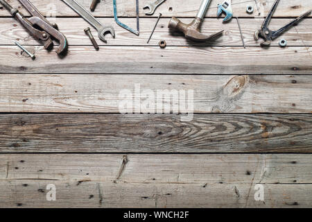 Flat lay composition with vintage carpentry tools on rough wooden background. Top view workbench with carpenter different tools. Woodworking, craftsma Stock Photo