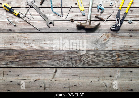 Flat lay composition with vintage carpentry tools on rough wooden background. Top view workbench with carpenter different tools. Woodworking, craftsma Stock Photo