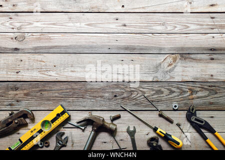 Flat lay composition with vintage carpentry tools on rough wooden background. Top view workbench with carpenter different tools. Woodworking, craftsma Stock Photo