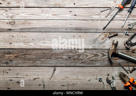 Flat lay composition with vintage carpentry tools on rough wooden background. Top view workbench with carpenter different tools. Woodworking, craftsma Stock Photo