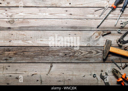 Flat lay composition with vintage carpentry tools on rough wooden background. Top view workbench with carpenter different tools. Woodworking, craftsma Stock Photo