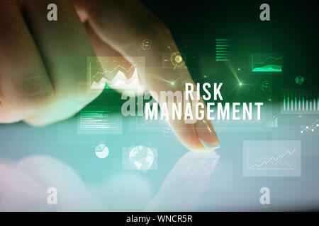 Finger touching tablet with charts and RISK MANAGEMENT inscription, business concept Stock Photo