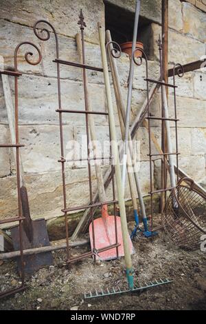 Vertical shot of garden tools leaned on a wall Stock Photo