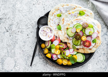 Homemade Italian mini foccacia with sauce and colorful vegetables. Gluten free flatbread with colorful tomatoes, cucumber, redish and red onion. Healt Stock Photo