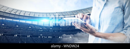 Composite image of mid section of businessman using digital tablet Stock Photo