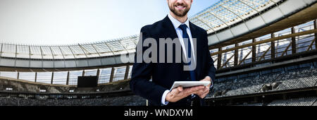 Composite image of portrait of smiling businessman holding digital tablet Stock Photo