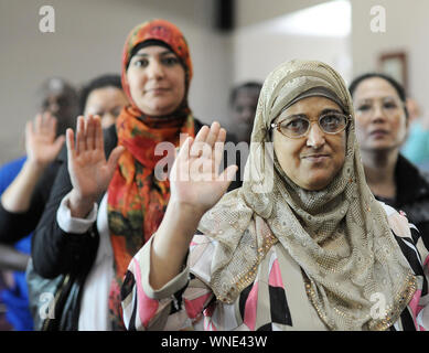 Thana Samhan (right) of Pakistan takes the oath to become a US citizen during a naturalization ceremony in which 35 citizens from 18 countries because Stock Photo