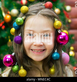 Little Girl With A Garland And Christmas Balls Her Hair On Her