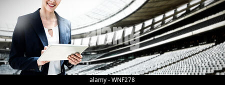 Composite image of portrait of beautiful smiling businesswoman using digital tablet Stock Photo