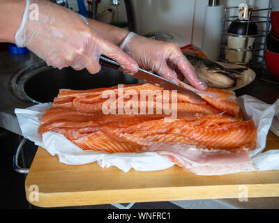 man filleting salmon at fish cleaning station Stock Photo - Alamy