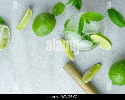 A top down view of a mojito cocktail made from fresh mint and lime in a cut glass tumbler against a pale background Stock Photo