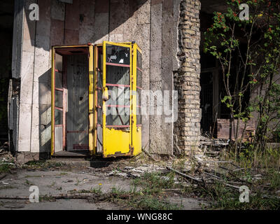 Old rusty classic soviet yellow telephone booth (aka telephone kiosk, telephone call box, telephone box or public call box)  in Pripyat city, Chernoby