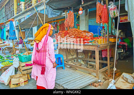 TAUNGGYI, MYANMAR - FEBRUARY 20, 2018: The elderly Bhikkhuni nun collects donations in agricultural market, on February 20 in Taunggyi. Stock Photo