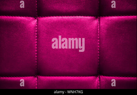 Shiny electric pink artificial textured leather stitched with thread. Close-up of sofa surface. View from directly above. Highly detailed background w Stock Photo