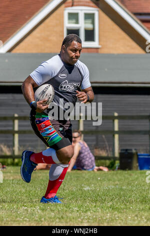 Amateur rugby touch player (male, 40-50 y) runs forwards with rugby ball in hand Stock Photo