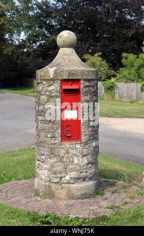 English village Red Post Box set into a round stone structure Stock Photo