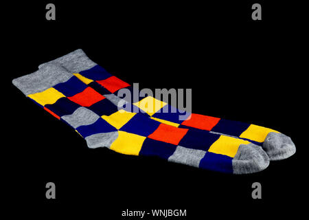 Bright multi coloured socks isolated against a black background Stock Photo