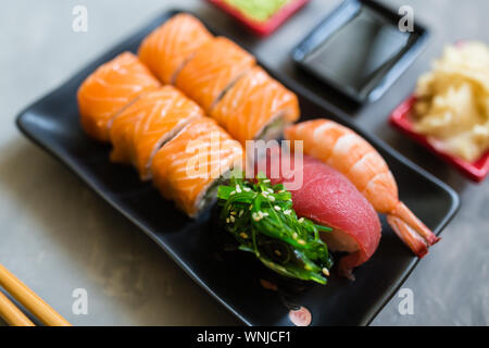 Top view on traditional japanese empty with sushi, ginger, soy sauce, wasabi bowl and chopsticks on concrete gray background. Online asian food Stock Photo
