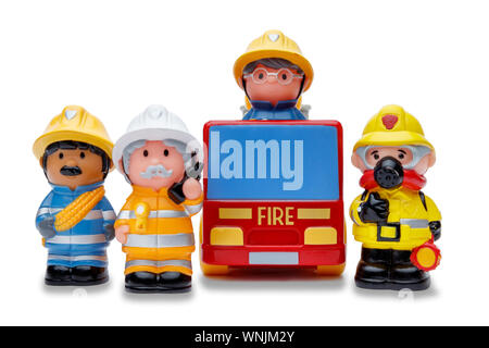A line of 3 toy firefighters standing to attention, and a fire engine, shot on a white background Stock Photo
