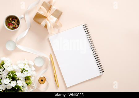 Romantic flatlay composition with diary, gift box, flowers bouquet, ribbon, candles, tea cup on pastel pink background. Flat lay, top view, copy space Stock Photo