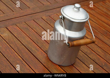 Vintage metal milk can on a wooden table Stock Photo