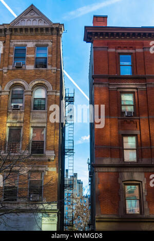 Two typical brownstone buildings against a beautiful blue summer sky, Harlem, New York, NYC, USA Stock Photo