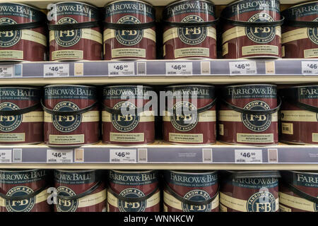 Tins of Farrow & Ball paint for sale on shelves in a DIY shop. Stock Photo