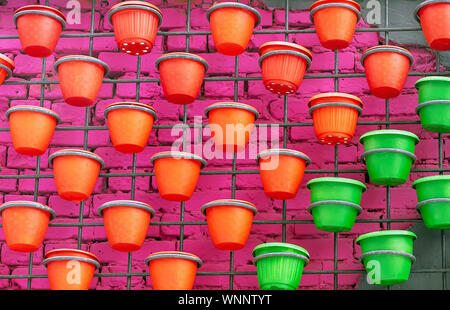 Plastic flower pots on a brick wall background. Stock Photo