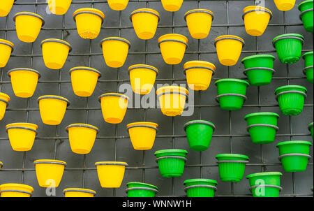 Plastic flower pots on a brick wall background. Stock Photo